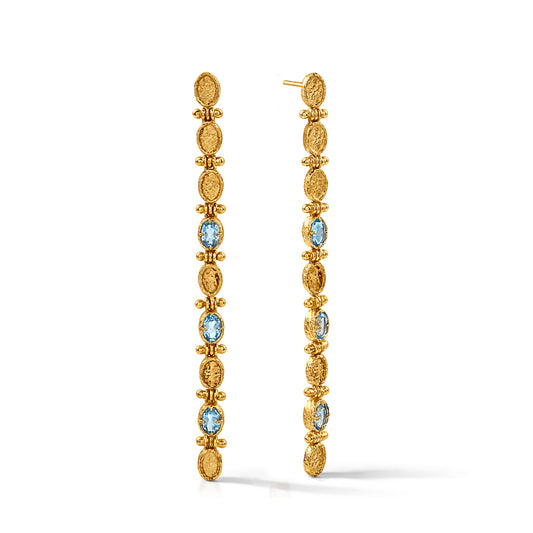 Gold earrings with blue gemstones on a white background