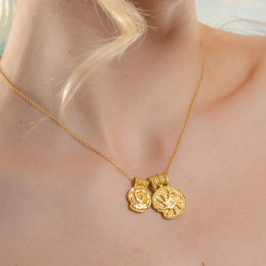 A gold-Plated  necklace with two pendant charms featuring ancient symbols.