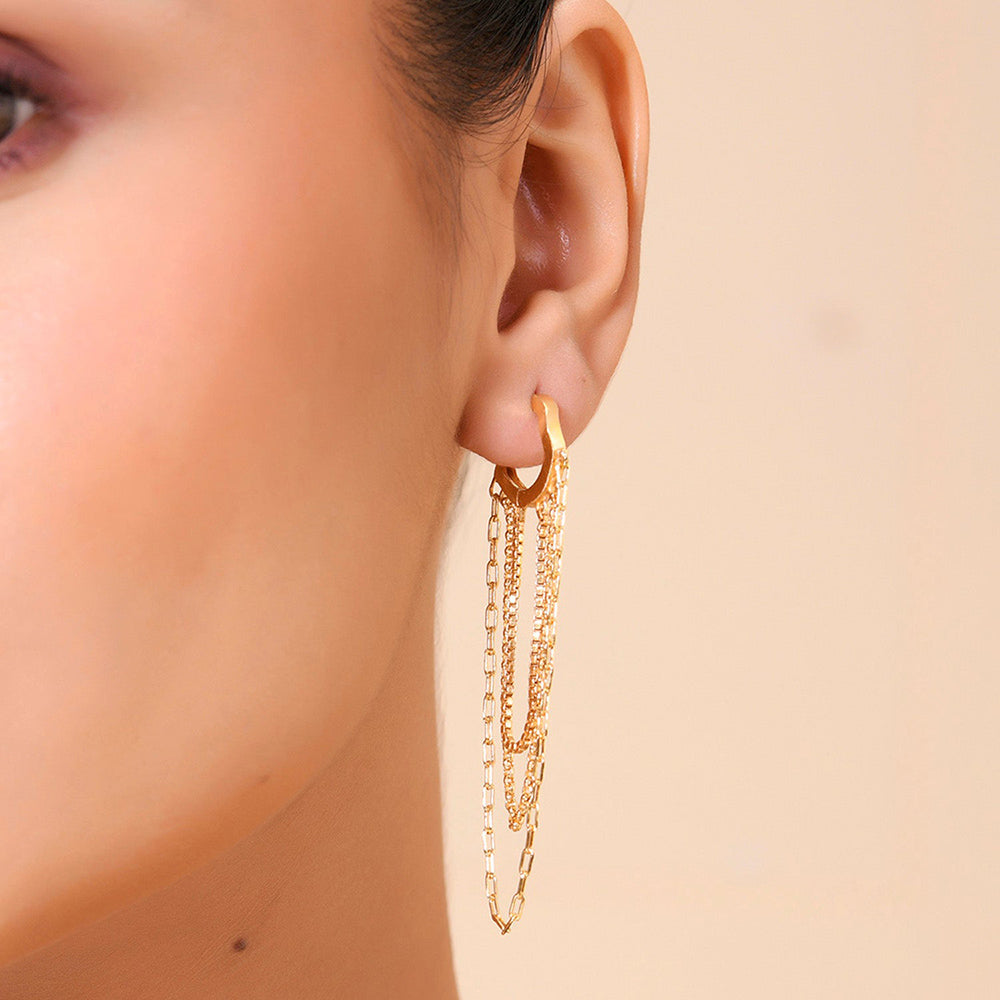 A close-up image of a woman's ear wearing a gold-colored hoop earring with intricate chain details by arvino.