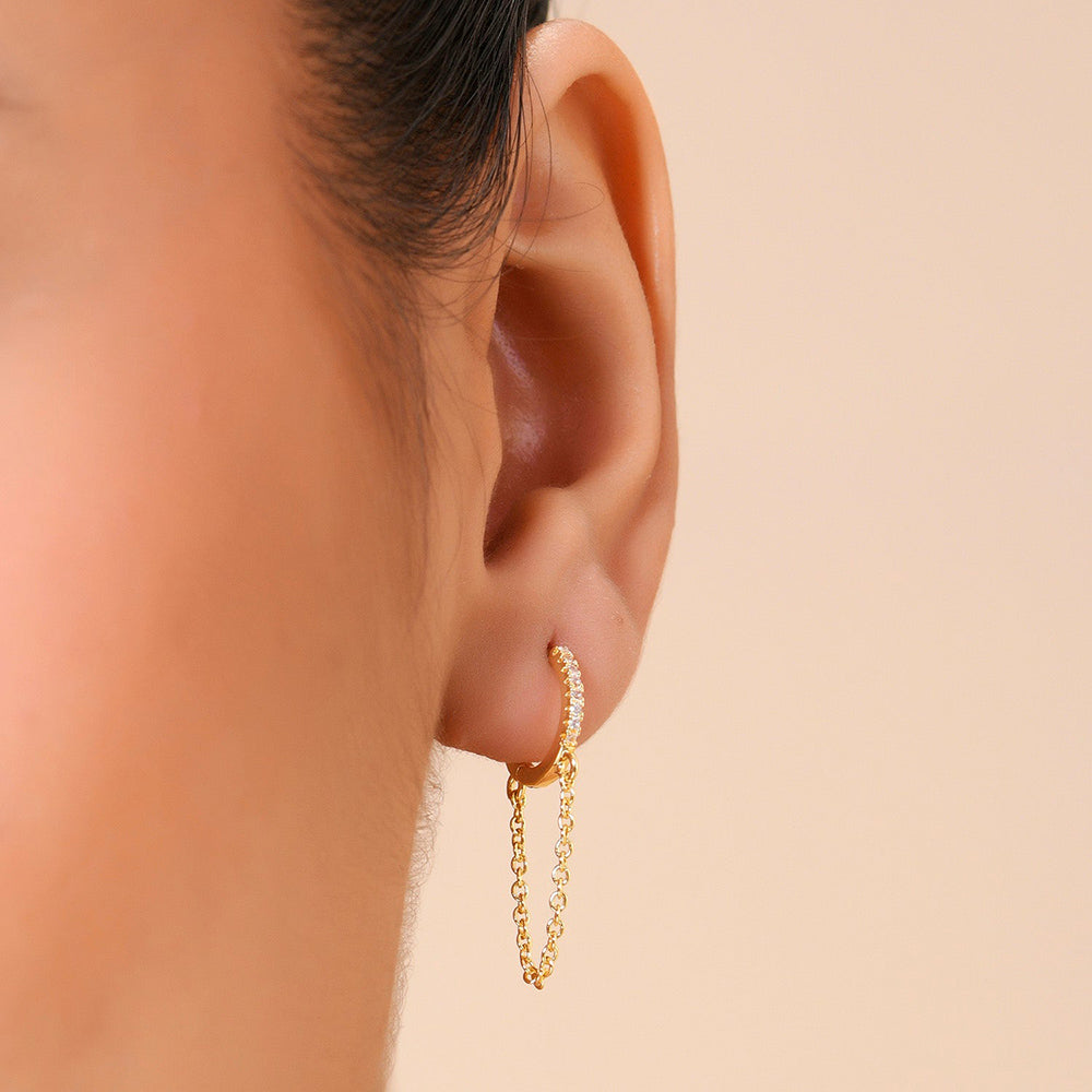 Model wearing a chained huggies earrings by arvino