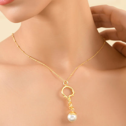 A model wearing a Dewy Pearl Twist 92.5 Sterling Silver Necklace with a luminous baroque pearl suspended from a delicate satellite chain with dewdrop accents and beaded detailing.