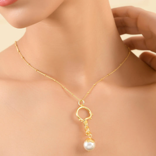 A model wearing a Dewy Pearl Twist 92.5 Sterling Silver Necklace with a luminous baroque pearl suspended from a delicate satellite chain with dewdrop accents and beaded detailing.