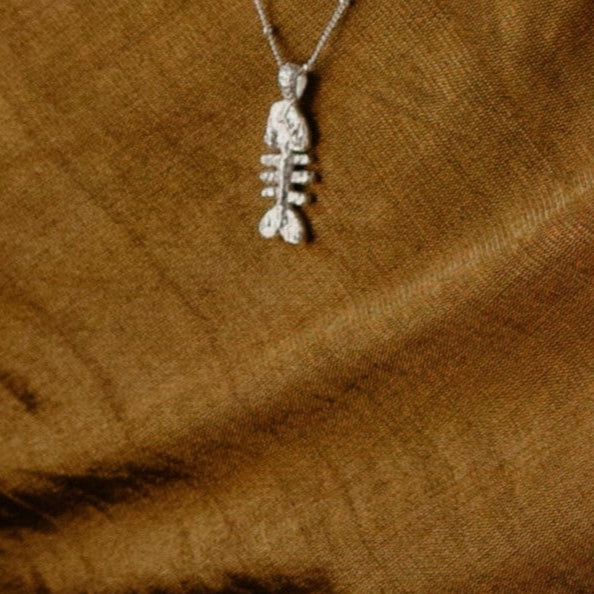 Close Shot of Fish bone necklace in pure 925 sterling silver with a brown like background
