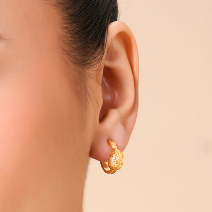 A close-up image of a woman's ear wearing a Gold plated Asteroid Hoop Earrings By Arvino