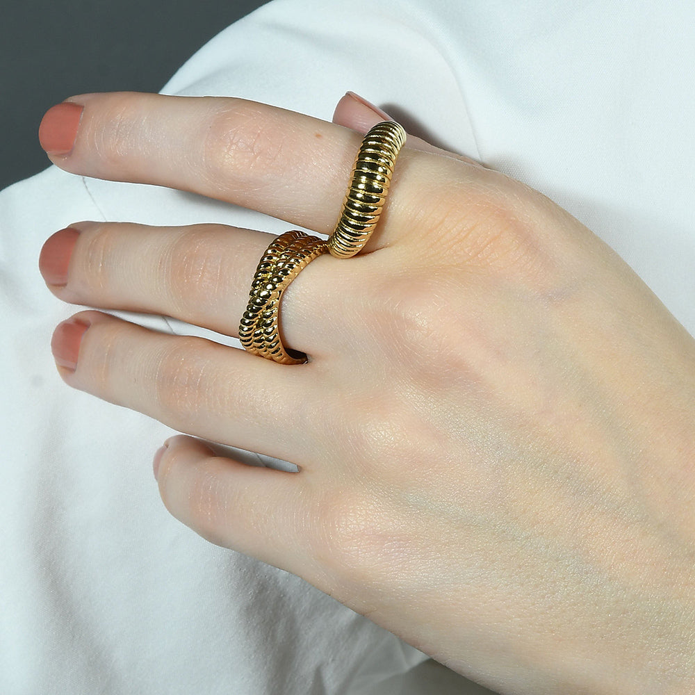 Close up image of a person stacking Intertwined Rope Ring  with a spiral like design ring by arvino.