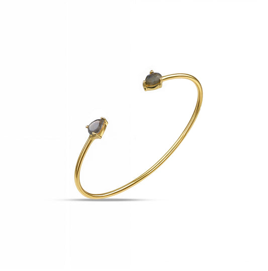 A gold-plated cuff bracelet with labradorite stones on either edge, displaying an iridescent glow.