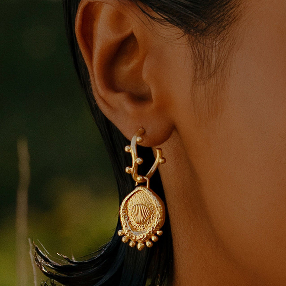 A close-up image of a woman's ear wearing Gold Plated Morsel Shell Earring By Arvino