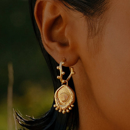 A close-up image of a woman's ear wearing Gold Plated Morsel Shell Earring By Arvino