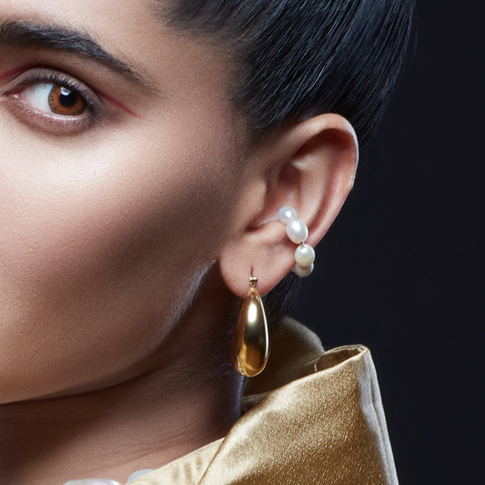 A person wearing a pearl weave ear cuff with a gold plating finish From arvino