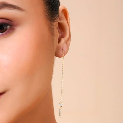 A person wearing a sterling silver threader earring with a zircon-studded bar.