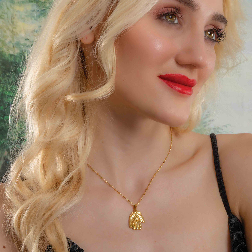 Model Wearing a gold plated Sculpted Hand Charm necklace by Arvion. Best Demi Fine Jewelry By Arvino