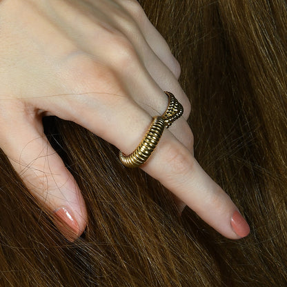 A person's hand displaying a gold-plated sculpted ridge ring on their finger.