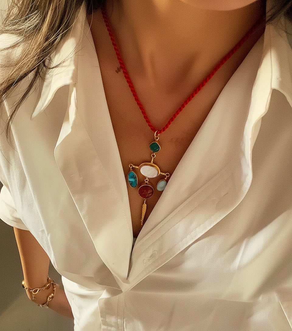 Close-up of a person wearing a white shirt with a colorful necklace and bracelet.
