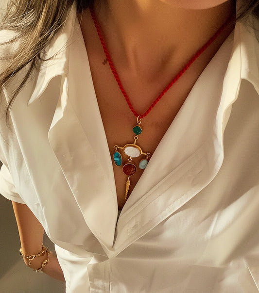 Close-up of a person wearing a white shirt with a colorful necklace and bracelet.