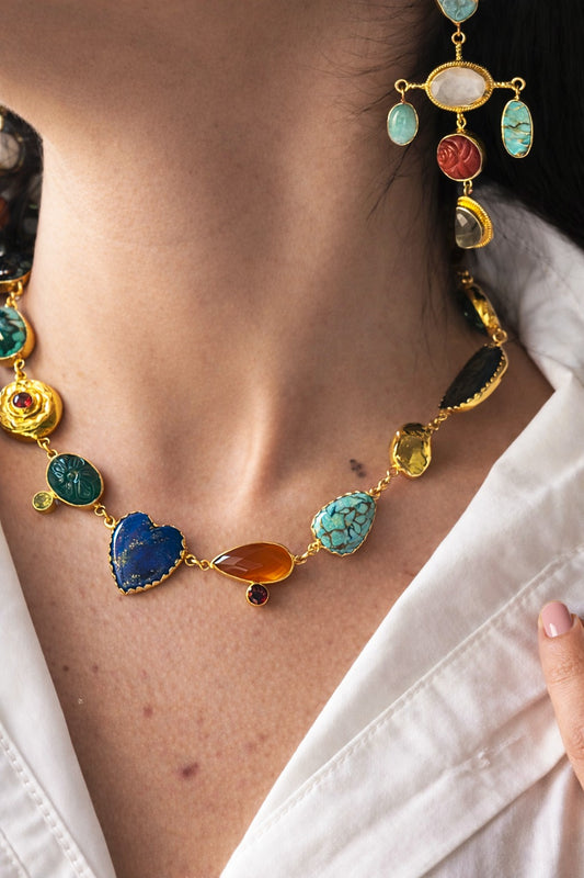 Colorful gemstone necklace worn by a person with a white shirt